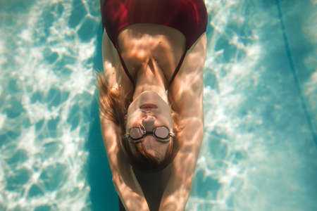 close up underwater portrait of woman in swimsuit and glasses