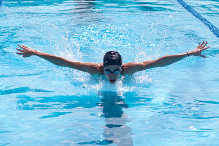 professional swimmer sportswoman butterfly swimming stroke in sportive swimming pool, front viewの写真素材