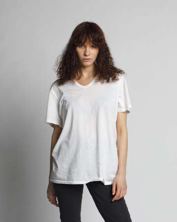 young curly woman in blank white t-shirt isolated on white backgroundの写真素材