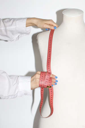 Anonymous Fashion Designer Working With ruler and Mannequin In White Studioの写真素材