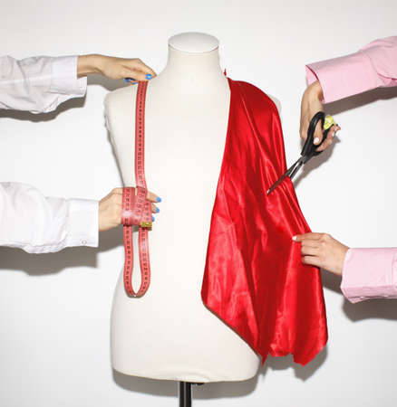 Anonymous Fashion Designers Working With red cloth and Mannequin In White Studioの写真素材