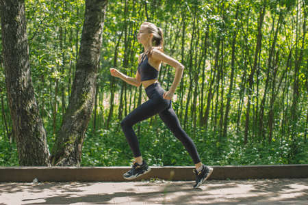 young woman jogging in green forest, outdoor running