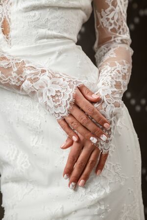 Beautiful sexy blonde girl in white wedding dress posing at a metal wallの写真素材