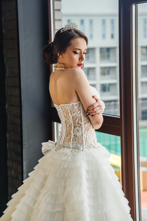 Beautiful girl in wedding dress posing in the bathroom, the interiorの写真素材