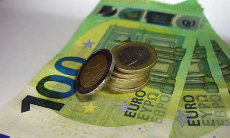 Euro coins on several 100 Euro bills.