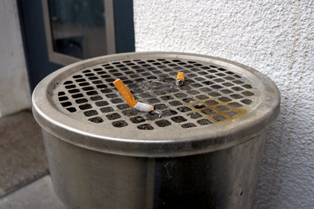 Cigarette butts in a trash can on the street