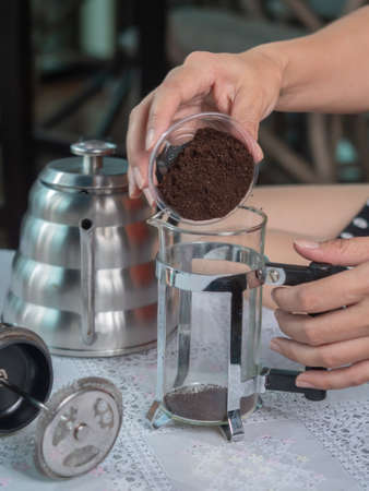 Closeup preparing to make coffee by french press technic, pouring ground coffee into the jar.の写真素材