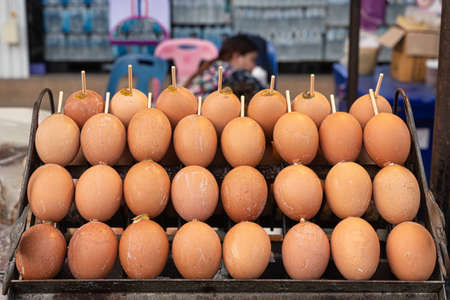 Grilled or toasted eggs on skewer on the grill. Thai street food or typical local food. Food concept.の写真素材