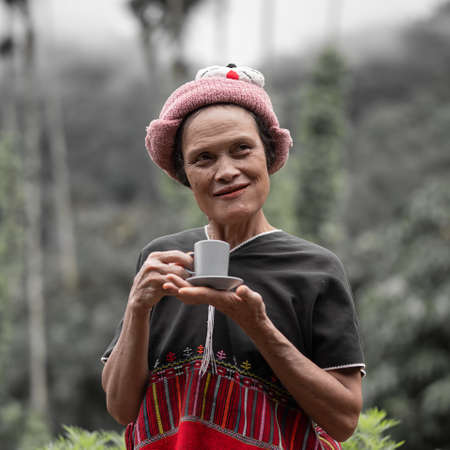 Mae Hong Son, Thailand - September 24, 2020 : Old Karen woman holding coffee cup and saucer.のeditorial素材