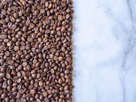 Half frame of coffee beans with marble background. Roasted coffee bean on the marble. Half screen of coffee beans, top-down shot.の写真素材
