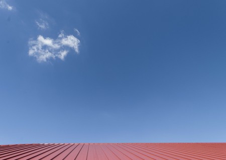 Red roof tile and blue sky with cloud.