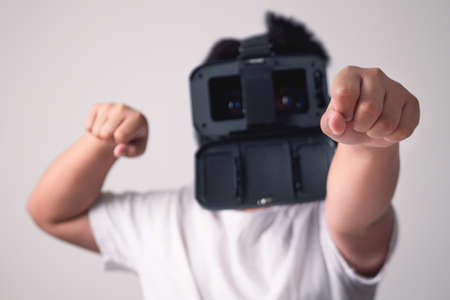 The child play VR box without smartphone. Fighting poses isolated on white and grey background. This...