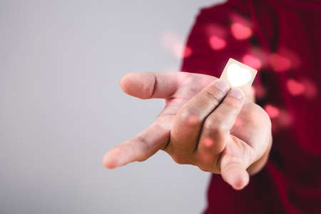 Person shows hands sign of love with heart visual effect. The man with red shirt in medium close up...