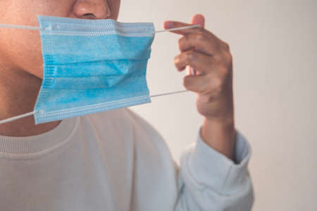 He is preparing a medical mask to wear in correct way. Protection global pandemic of coronavirus. Other name of this disease calls COVID-19. Copy space for text.の写真素材