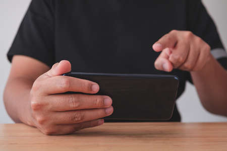 The man use a smartphone for work, social media and relaxation. Medium close up shot.の写真素材
