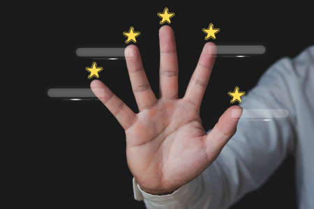 Customer review concept. Around the hands, there are five stars. There are boxes for text. Close up shot isolated on black background.の写真素材