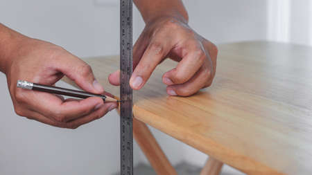 Measurement concept. Someone measures a handcraft of table by ruler. Easy DIY work or handcraft.の写真素材