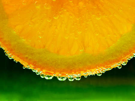 Fresh slice of orange with bubblesの写真素材