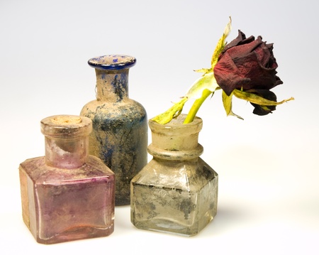 Odl styled dirty glass bottles with dry rose flowerの写真素材