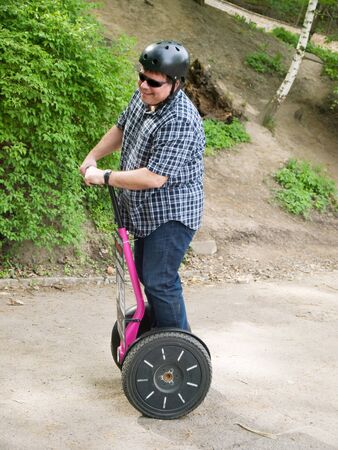 Mature man driving on segwayの写真素材