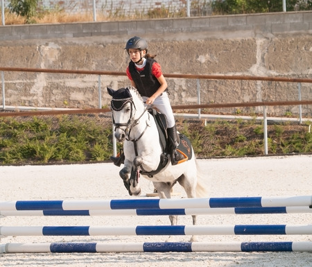 Girl with roan pony on showjumping competitionの写真素材