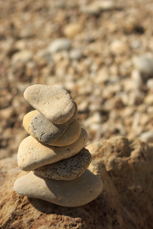 Stones pyramid on pebble beach symbolizing stability, zen, harmony, balanceの写真素材