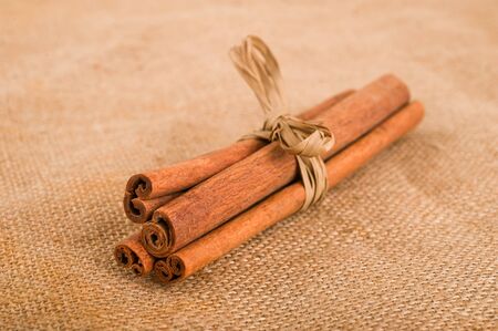 Cinnamon sticks on jute backgroundの写真素材