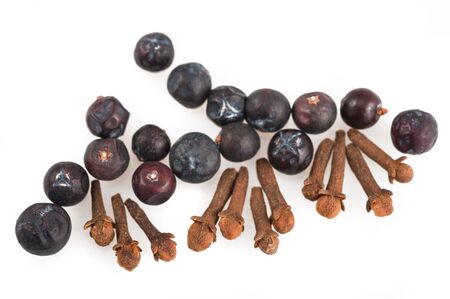 Juniper berries and cloves isolated on whiteの写真素材