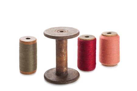 Colored threads wound on bobbins isolated on white