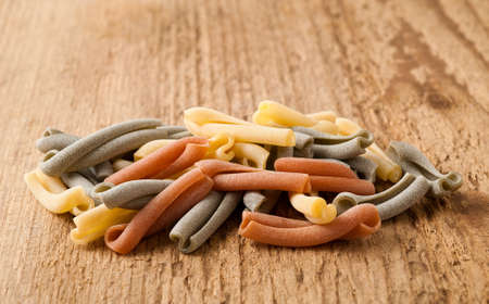 Colorful strozzapreti italian pasta on wood backgroundの写真素材