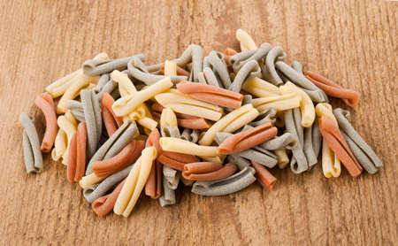 Colorful strozzapreti italian pasta on wood backgroundの写真素材
