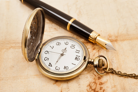fountain pen and pocketwatch on old parchmentの写真素材