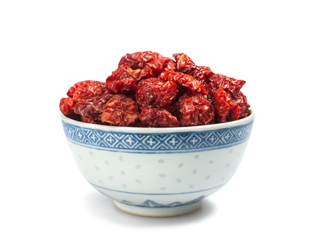 Dried tomatoes in a cup  isolated on white background の写真素材