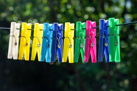 Group of multicolor clothespins hanging on a rope