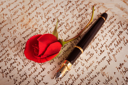 Red rose and fountain pen on a lettersの写真素材