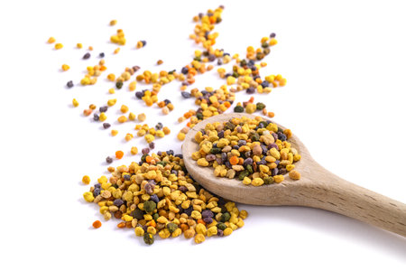 Wooden spoon with bee pollen isolated on whiteの写真素材