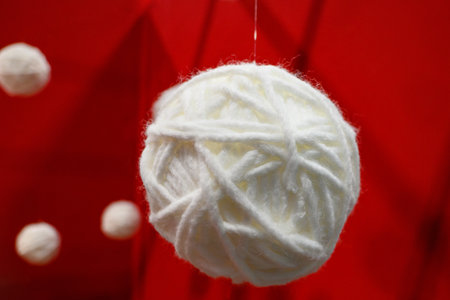 Ball of white wool on red backgroundの写真素材