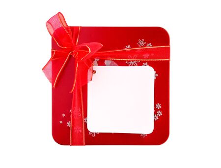 Red gift box with ribbon and blank note tag isolated on white backgroundの写真素材