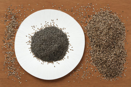 Chia seeds in a white plate on a wooden background. View from above.の素材