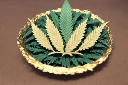Cannabis leaf on a golden plate. Cannabis leaf on a brown backgroundの素材