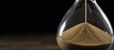 Hourglass image depicting flowing sands symbolizing relentless passage of timeの素材
