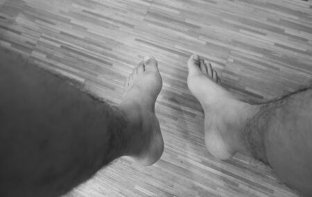Human legs with the hair on the shin on the floor