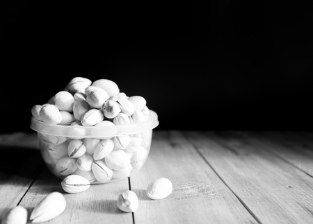 Pistachio put in the bowl and some the wood floorblackwhite