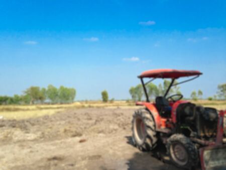 Blur farming view with tractor machine and blue skyの写真素材