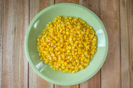 Corn in the bowl put on wood tableの写真素材