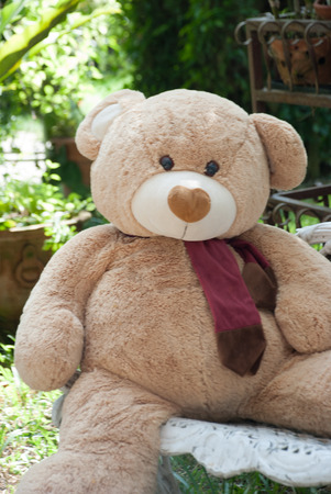 Alone thinking concept by bear doll sit on the seat in gardenの写真素材