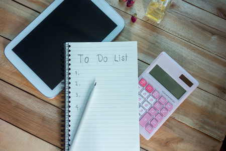 To do list notebook with tablet calculator pencil on wood floor , digital effect vintage style