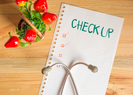 Health Check up list concept, top view of paper check list and Stethoscope on wood table , digital effect vintage styleの写真素材