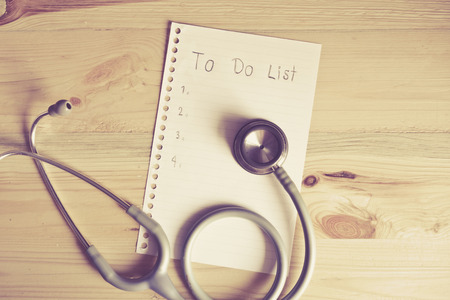 Top View "To do list" on wood table with stethoscope , digital effect for vintage styleの写真素材