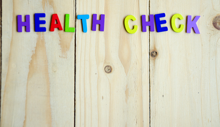Health check colorful text with copy space on wood table backgroundの写真素材